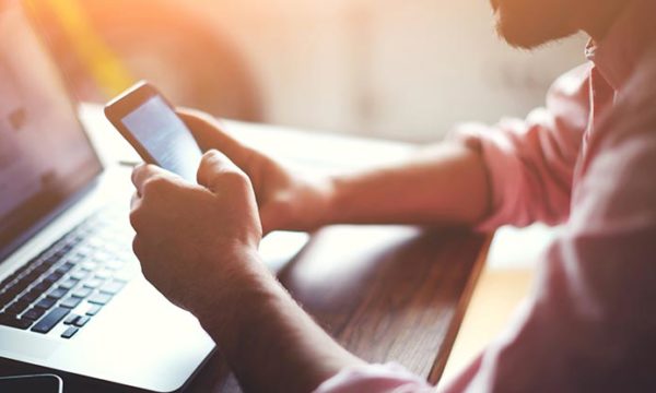 woman using laptop and smartphone to work from home