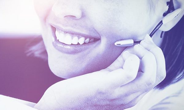 woman who works from home is smiling while talking to customer over the phones