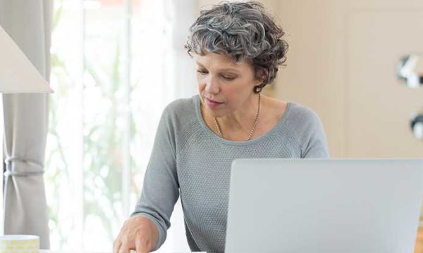 woman working from home using headset and laptop