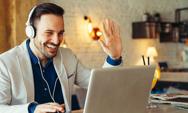happy man working from home using laptop and headphotes