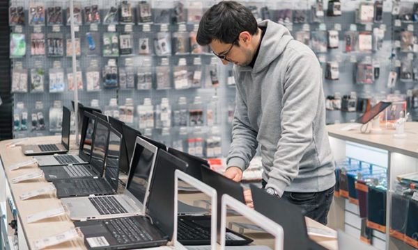 man inside a store buying a computer for work at home