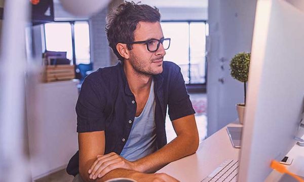 man looking at computer home office working from home