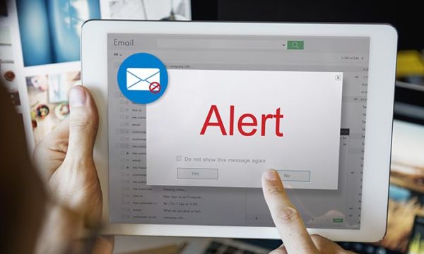 woman holding a tablet with an alert sign to avoid work at home scams