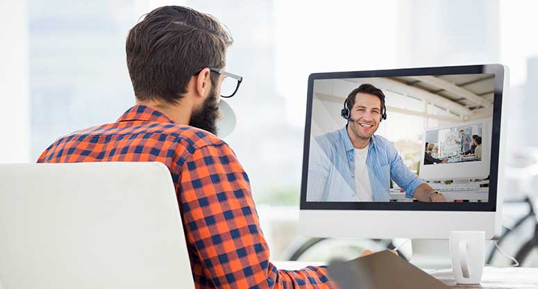 man communicating with remote coworker from home job