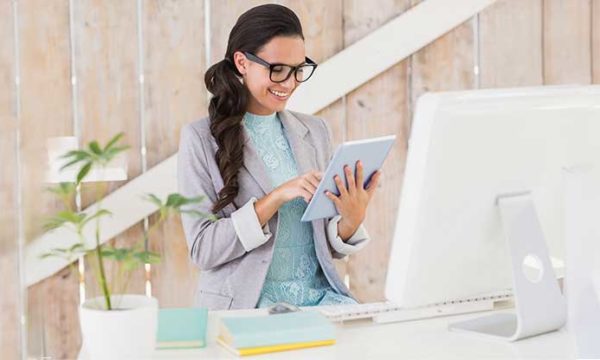 woman working from home using tablet and desktop to work from home
