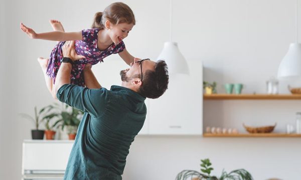 father holding daughter during a break after working from home
