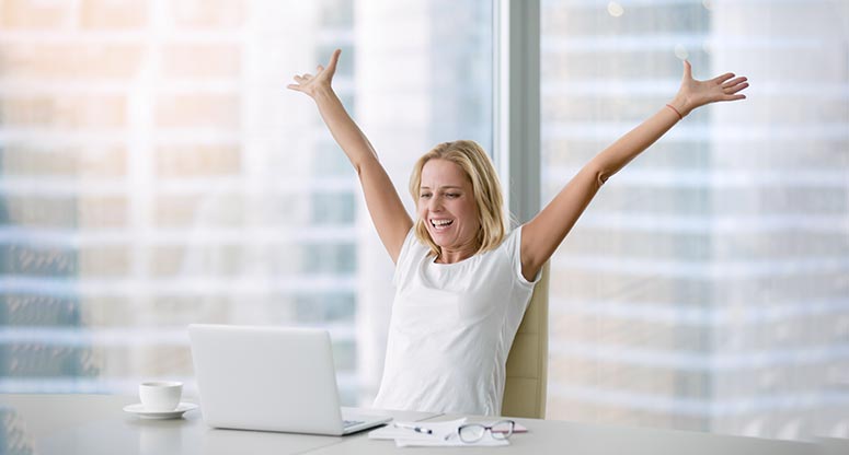 work from home woman celebrating from home desk