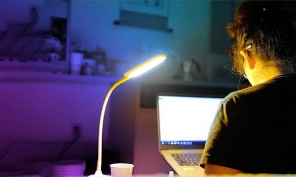 woman working from home at night from a work at home desktop