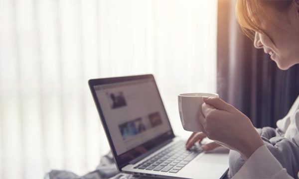 woman sipping on a cup of coffee looking at laptop best places to work from home