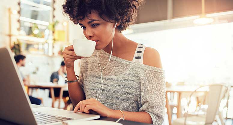 woman working from cafe and being productive while drinking coffee