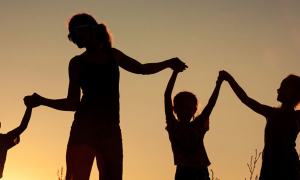 Happy family silhouetted against a gold sunset