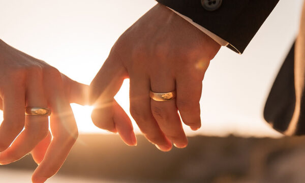Close-up shot of holding hands wearing wedding rings together