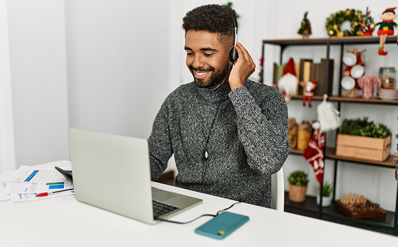 Young call center agent working from home during the holiday season and taking calls