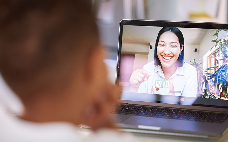 Elementary tutor virtually assists child to learn letters via video chat from the comfort of her home