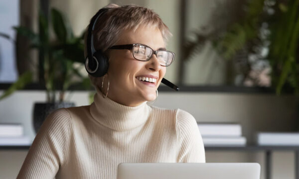 Mature competent sales agent takes phone calls with clients in her home office