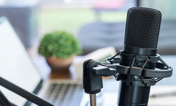 Podcast microphone paired with a laptop in a creative studio