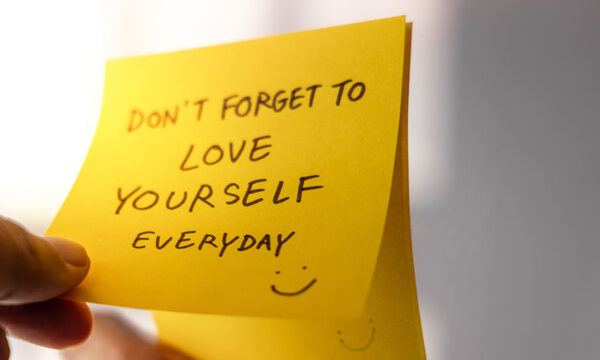 A sticky note stuck to a mirror that says "Don't forget to love yourself everyday :)"