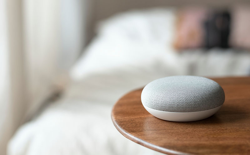 At-home-voice-activated speaker sitting on a counter in a bedroom