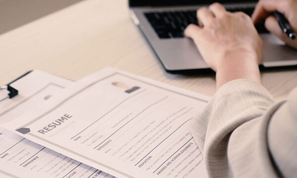 Job recruiter analyzes different resumes for a job as they type on their computer