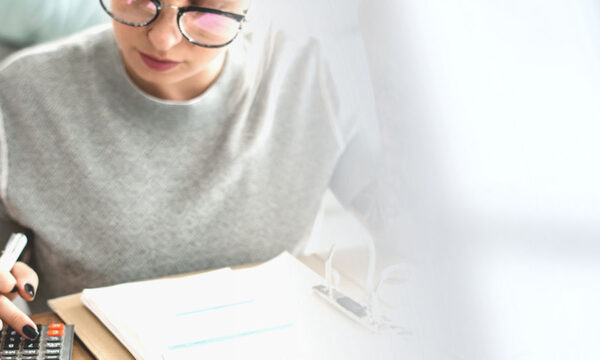 Young aspiring business professional calculates for their remote gig using a calculator