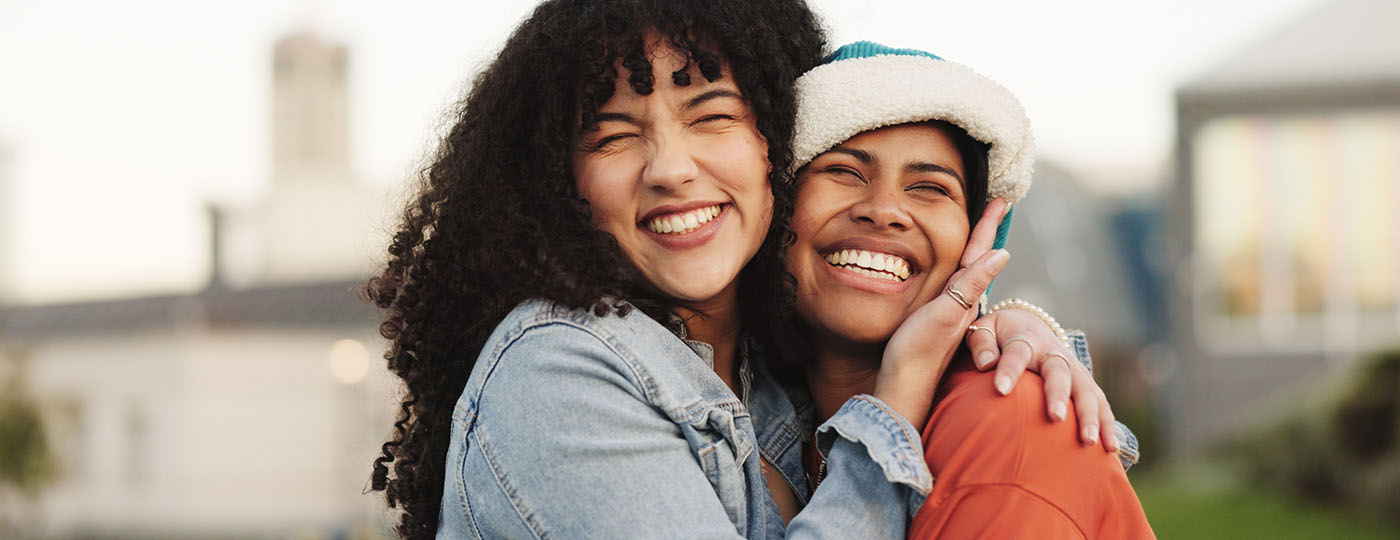 Two friends hug and smile together