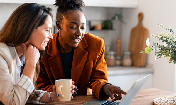 Two intelligent professional women laughing together as they take an education course together